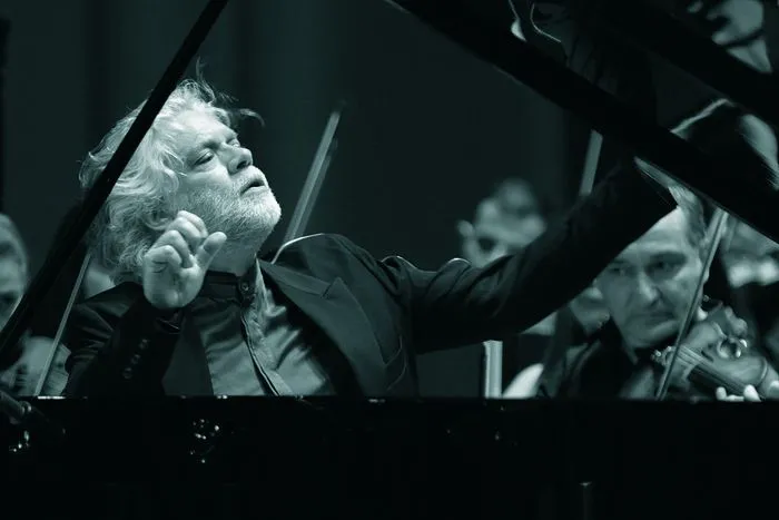 Director de orquesta con cabellos blancos dirigiendo una orquesta sinfónica durante una representación de la Saga Beethoven en Burdeos