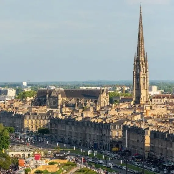 Vista aérea de Burdeos mostrando la Flecha de Saint-Michel dominando el centro histórico con sus edificios de piedra y tejados mansardos.