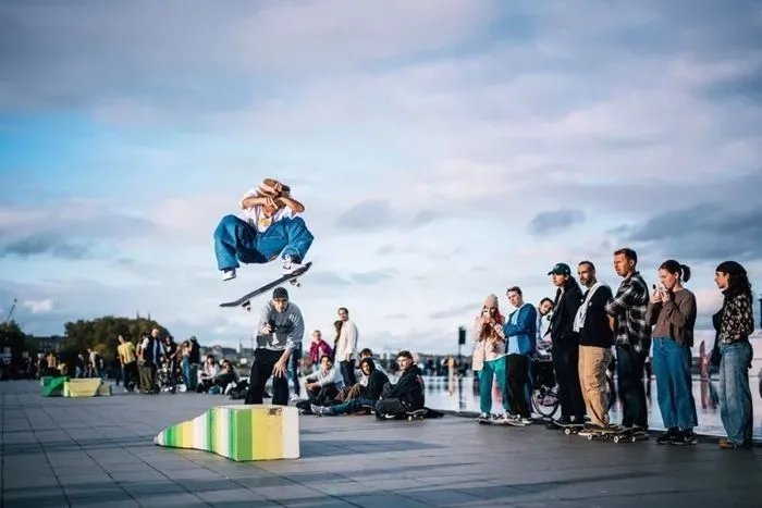 Un patinador realiza un salto acrobático sobre un obstáculo colorido durante el festival Connect en Burdeos, ante una multitud de espectadores