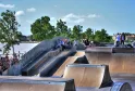 Parque de skate de Burdeos con rampas de hormigón y espectadores, vista al río Garona y la arquitectura de la ciudad