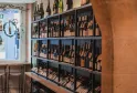 Estantería de vinos con marcos negros que contienen múltiples botellas de vino tinto y blanco en una tienda de vinos de Burdeos.